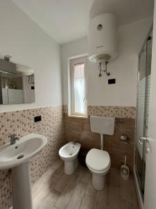 La salle de bains est pourvue de toilettes, d'un lavabo et d'une douche. dans l'établissement Casa Vacanze Isabella, à Campofelice di Roccella