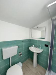 La salle de bains est pourvue de toilettes blanches et d'un lavabo. dans l'établissement Casa Vacanze Isabella, à Campofelice di Roccella