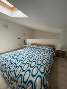 - une chambre avec une couette bleue et blanche sur un lit dans l'établissement Casa Vacanze Isabella, à Campofelice di Roccella