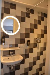 La salle de bains est pourvue d'un lavabo et d'un miroir. dans l'établissement Frisco Inn, à Amsterdam