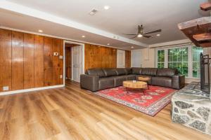 uma sala de estar com um sofá de couro e uma mesa em 40 Acres w/Waterfalls, Vineyard, Stream, 5 bedroom em Moravian Falls