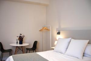 a bedroom with a bed and a table with chairs at Apartamentos Concepcion Centro in Albacete