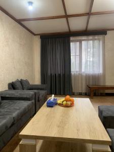 una sala de estar con una mesa con un bol de fruta. en Tsaghkadzor Villa en Tsaghkadzor