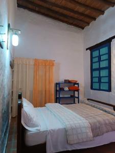 a bedroom with a bed and a window at La Casa del Mango in Pampatar