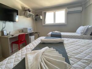 a bedroom with a bed and a desk with a computer at P1 Hotel in Santa Maria