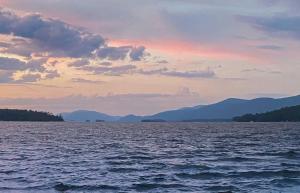 a view of a large body of water at sunset at Depe Dene Lakeside Resort in Lake George