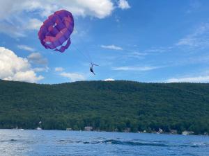 Depe Dene Lakeside Resort في بحيرة جورج: شخص يطير طائرة ورقية فوق هيئة ماء