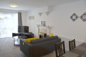 sala de estar con sofá y chimenea en Lindrick Villa- 3BD Bunglow , Free parking- Long stays, en Leicester