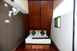 ein kleines Schlafzimmer mit einem Bett in einem Zimmer in der Unterkunft Misty Ghats Resort in Wayanad