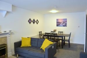 uma sala de estar com um sofá azul e uma mesa em Lindrick Villa- 3BD Bunglow , Free parking- Long stays em Leicester