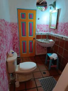 a bathroom with a toilet and a sink and a door at La Casa del Mango in Pampatar