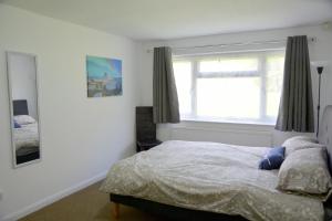 Schlafzimmer mit einem Bett und einem Fenster in der Unterkunft Lindrick Villa- 3BD Bunglow , Free parking- Long stays in Leicester