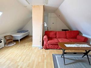 uma sala de estar com um sofá vermelho e uma mesa em Holiday home Ljungbyhed III em Ljungbyhed
