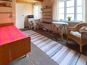 um quarto com uma cama, uma mesa e cadeiras em Holiday home Ljungbyhed III em Ljungbyhed