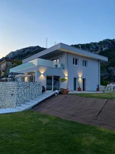 a large white house with a stone wall at B&B Garda Home in Nago-Torbole