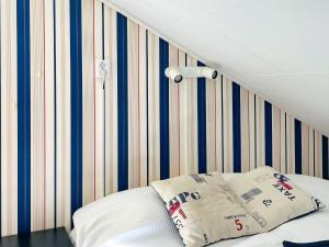 1 dormitorio con 1 cama con pared a rayas en Holiday home STENUNGSUND II, en Stenungsund
