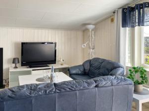 sala de estar con sofá azul y TV en Holiday home STENUNGSUND II, en Stenungsund