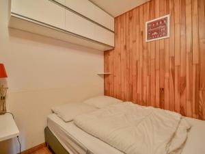 małe łóżko w pokoju z drewnianą ścianą w obiekcie Studio cosy au centre de Morzine - balcon sud, proche remontées mécaniques - 4 pers - FR-1-684-43 w mieście Morzine