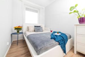 a white bedroom with a bed and a window at Apartament Graniczna 6B in Bydgoszcz