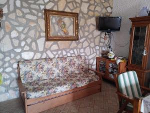 un soggiorno con un divano e una TV di La Pergola a Ischia