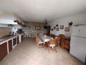 una cucina con tavolo, sedie e frigorifero di La Pergola a Ischia