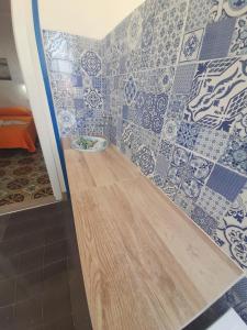 Baño con azulejos azules y blancos en la pared en Vulcano: La Porta Delle Eolie en Vulcano