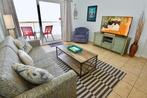 a living room with a couch and a tv at Caribbean 404 in Gulf Shores
