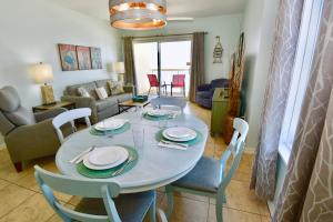 a dining room and living room with a table and chairs at Caribbean 404 in Gulf Shores
