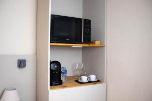 a microwave oven sitting on a shelf next to a table at Apartamentos Concepcion Centro in Albacete