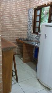 uma cozinha com um lavatório e um frigorífico em Condominio Costa do Sol Praia - 600mt da praia em Bertioga
