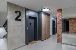 a row of elevators in a building with the number two at Apartament Graniczna 6B in Bydgoszcz