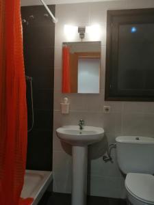 y baño con lavabo, aseo y espejo. en Apartamento Besiberri 7 planta baja con terraza, en Pla de l'Ermita