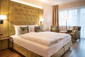 a bedroom with a large bed with a large headboard at Vitalpina Hotel Waldhof in Rablà