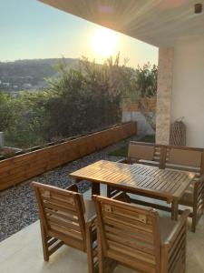 een houten tafel en stoelen op een balkon met uitzicht bij Villa Cellesina in Ulcinj