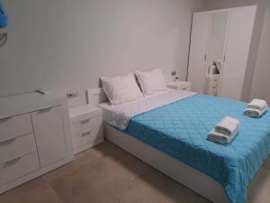 a small white bedroom with a bed and a dresser at ATEA APARTMENT KAVARNA in Kavarna