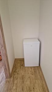 a small white refrigerator in a corner of a room at Privat Prešov in Prešov