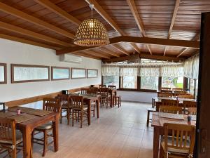 um restaurante com mesas e cadeiras de madeira e um lustre em Cunda Alibeyhan Otel em Cunda