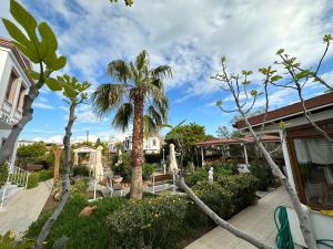 um quintal com palmeiras e um parque infantil em Cunda Alibeyhan Otel em Cunda