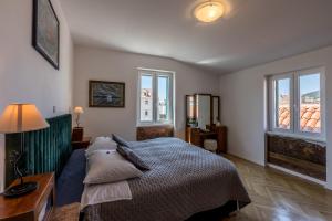 1 dormitorio con cama, mesa y ventanas en The Heart of Palace Apartment, en Split