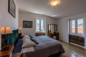 a bedroom with a bed and a table and windows at The Heart of Palace Apartment in Split