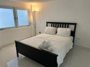 une chambre avec un lit avec des draps blancs et une fenêtre dans l'établissement Majestic 2-Bedroom Beachside Suite, à San Juan