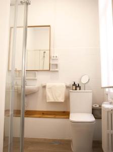 a bathroom with a toilet and a sink and a mirror at Apartamentos Centro in Albacete +15 photos