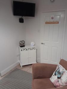 a living room with a couch and a flat screen tv at Lealt Falls House in Culnacnoc