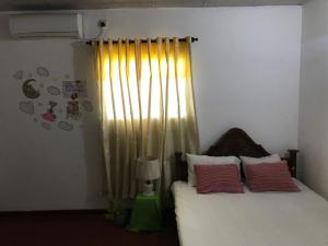 een slaapkamer met een bed met rode kussens en een raam bij Menara Villa in Kamburugamuwa