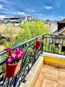 dos macetas en una barandilla en un balcón en M&M Center Apartment with free parking, en Plovdiv