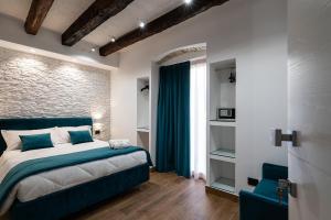 a bedroom with a blue bed and a brick wall at Sofi' Center Rooms in Sciacca