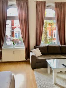 - un salon avec un canapé et 2 grandes fenêtres dans l'établissement Wohnung am Schlossgarten, à Schwerin