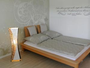 een bed in een kamer naast een muur bij Rosenalm - Appartement 30 in Scheidegg