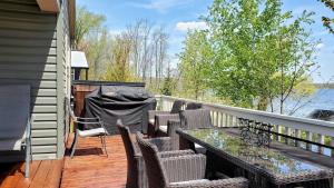 une terrasse avec une table et des chaises sur une maison dans l'établissement Lake Front Cottage, 5 Star Golf Course!! Spacious, Dream Resort!!, à Keene
