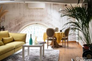 sala de estar con sofá amarillo y mesa en MURANO Suites BOUTIQUE Apartments, en Murano